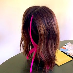 A 16” silk lace-front wig that is 100% human hair, dark brown with highlights.